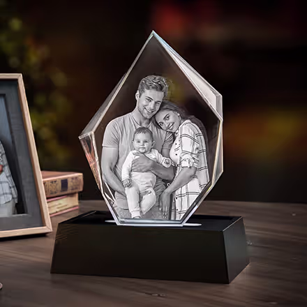 Cristal photo 3D Iceberg gravé avec des parents et leur bébé, présenté sur une base lumineuse LED noire à côté de la photo de famille originale.