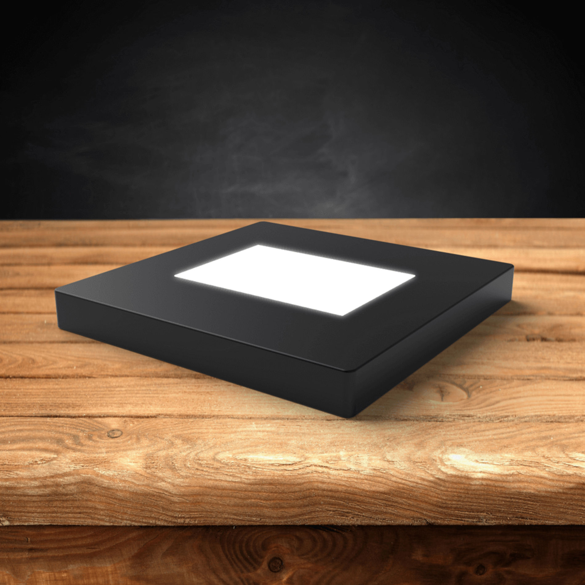 Base lumineuse LED en bois foncé sur une table en bois.